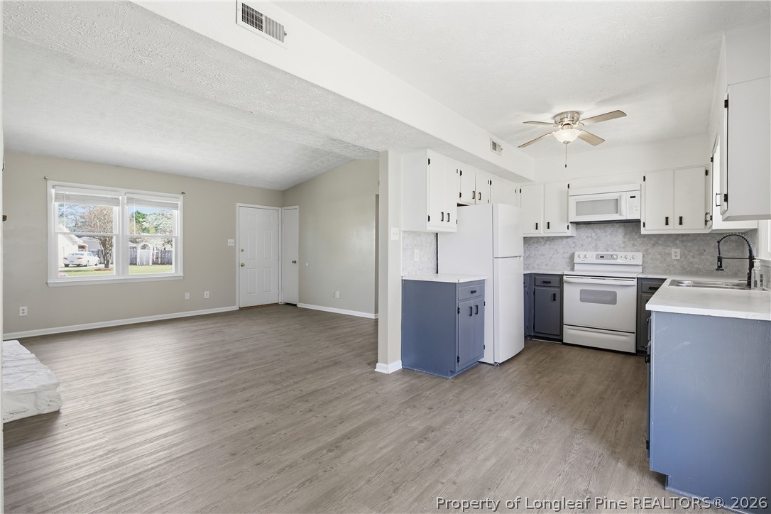 6319 Rustic Ridge Hope Mills, NC 28348 - Photo 17 of 39 a kitchen with cabinets wooden floor and stainless steel appliances