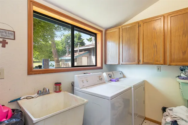 a utility room with a window a sink and a cabinets