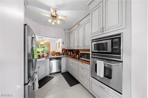 a kitchen with granite countertop cabinets stainless steel appliances and a chandelier