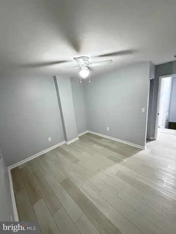 an empty room with fan and entrance