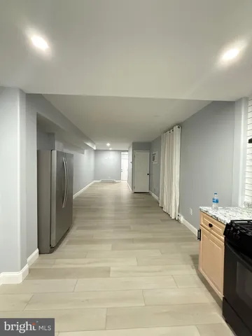 a view of a hallway with wooden floor and a living room