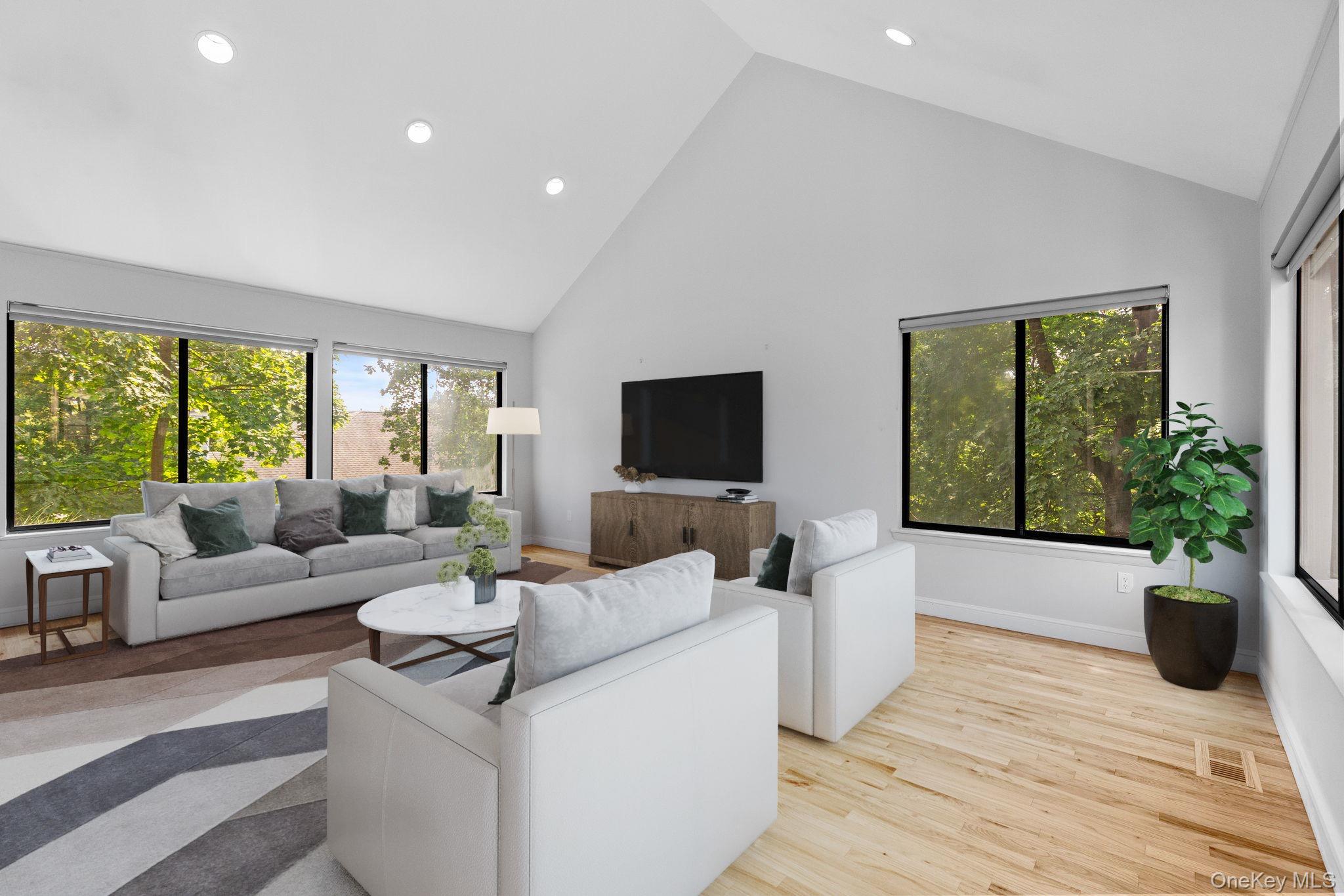 27 Stone Cabin Road New Rochelle, NY 10801 - Photo 13 of 24 Living room featuring high vaulted ceiling, visible vents, baseboards, wood finished floors, and recessed lighting (virtually staged)