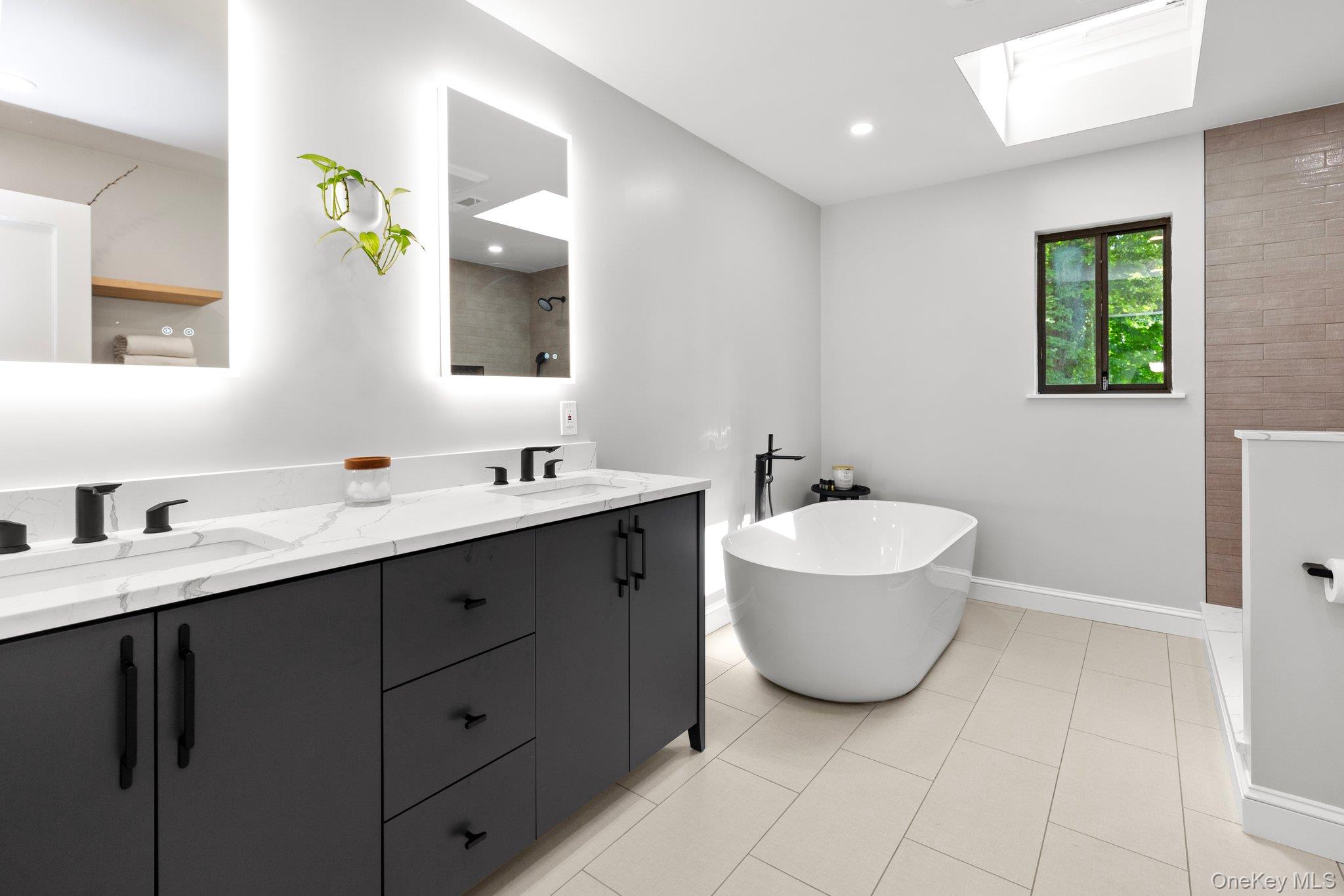 27 Stone Cabin Road New Rochelle, NY 10801 - Photo 17 of 24 Bathroom with a soaking tub, a skylight, double vanity, tiled shower, and a sink