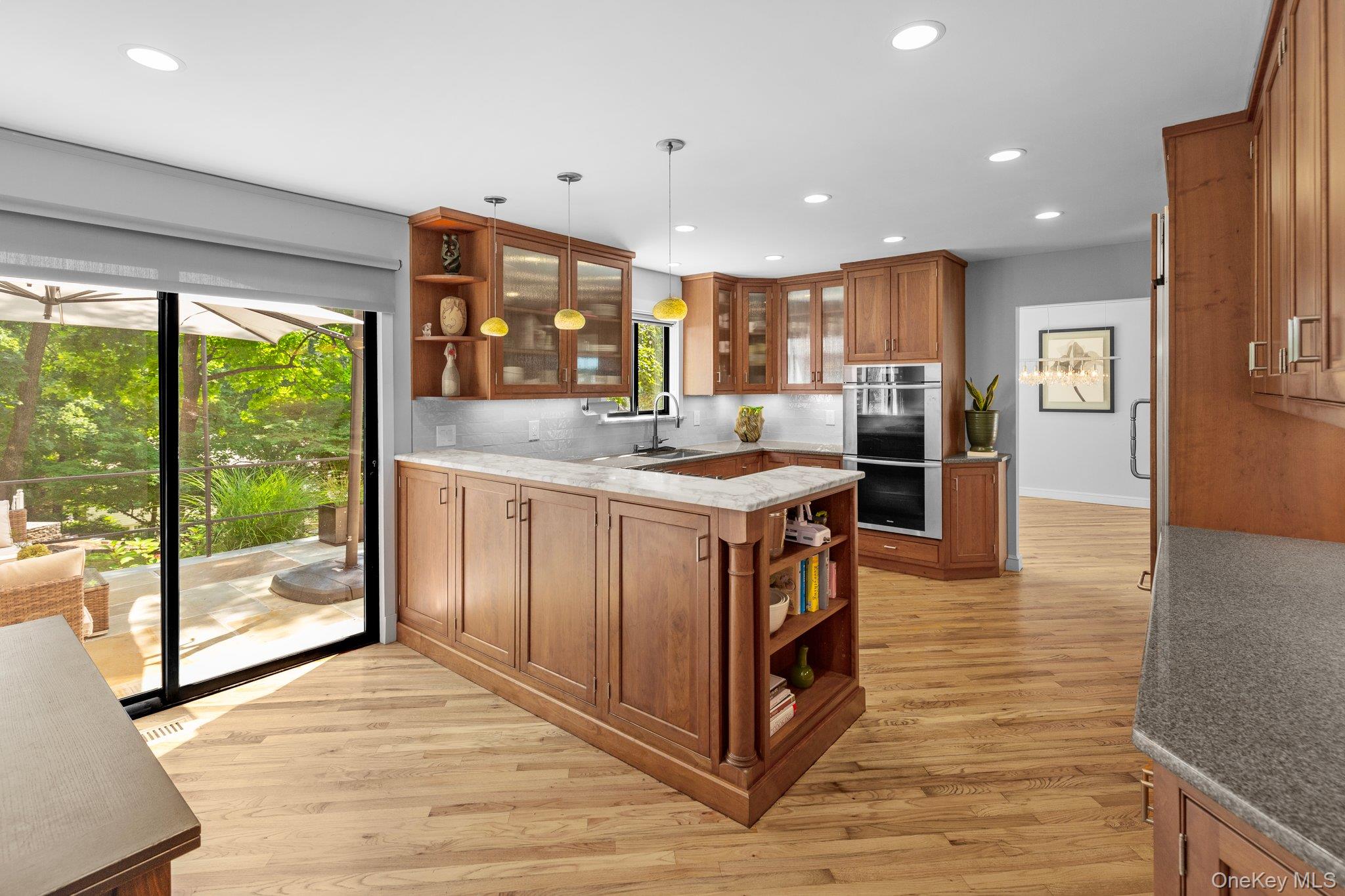 27 Stone Cabin Road New Rochelle, NY 10801 - Photo 8 of 24 Kitchen featuring stainless steel double oven, brown cabinets, open shelves, and plenty of natural light