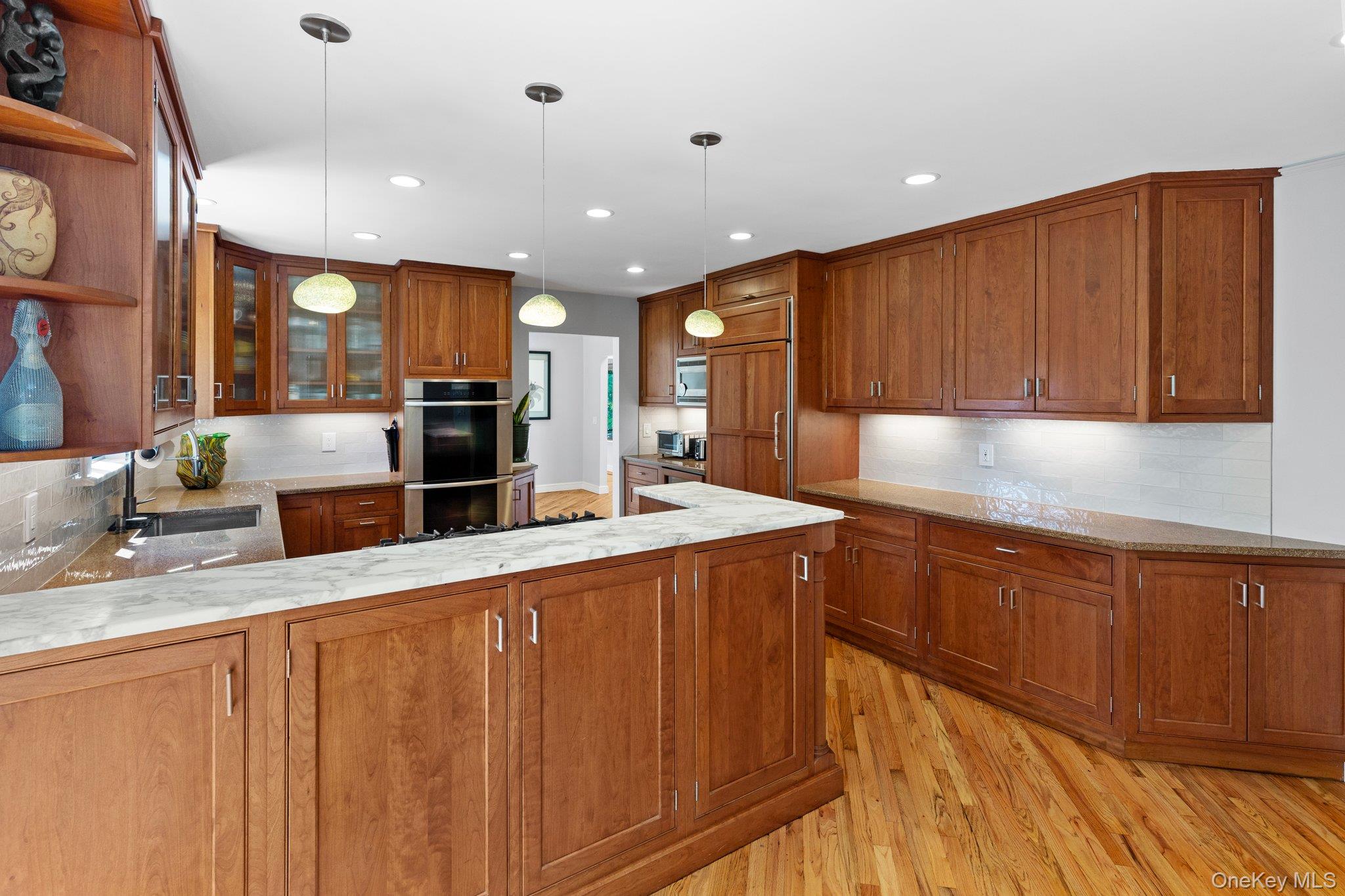 27 Stone Cabin Road New Rochelle, NY 10801 - Photo 9 of 24 Kitchen featuring open shelves, brown cabinetry, a sink, and stainless steel double oven