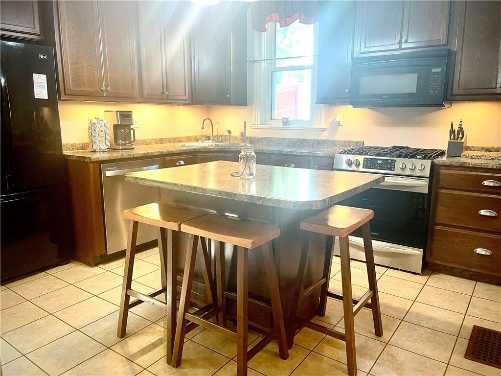 224 West Pearl Street Butler, PA 16001 - Photo 6 of 30 a kitchen with granite countertop a stove a sink and a dining table with granite countertops
