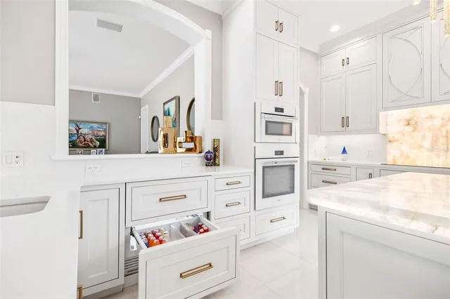 a kitchen with white cabinets stainless steel appliances and sink