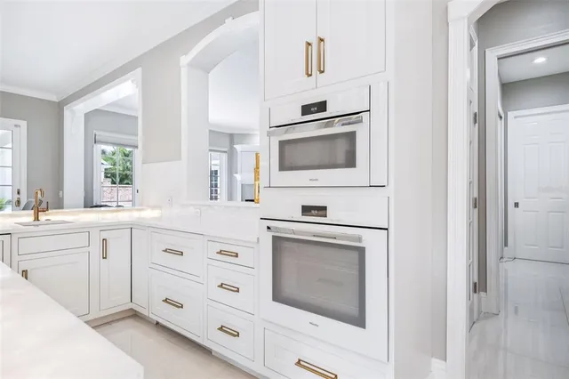 a kitchen with granite countertop white cabinets and white appliances