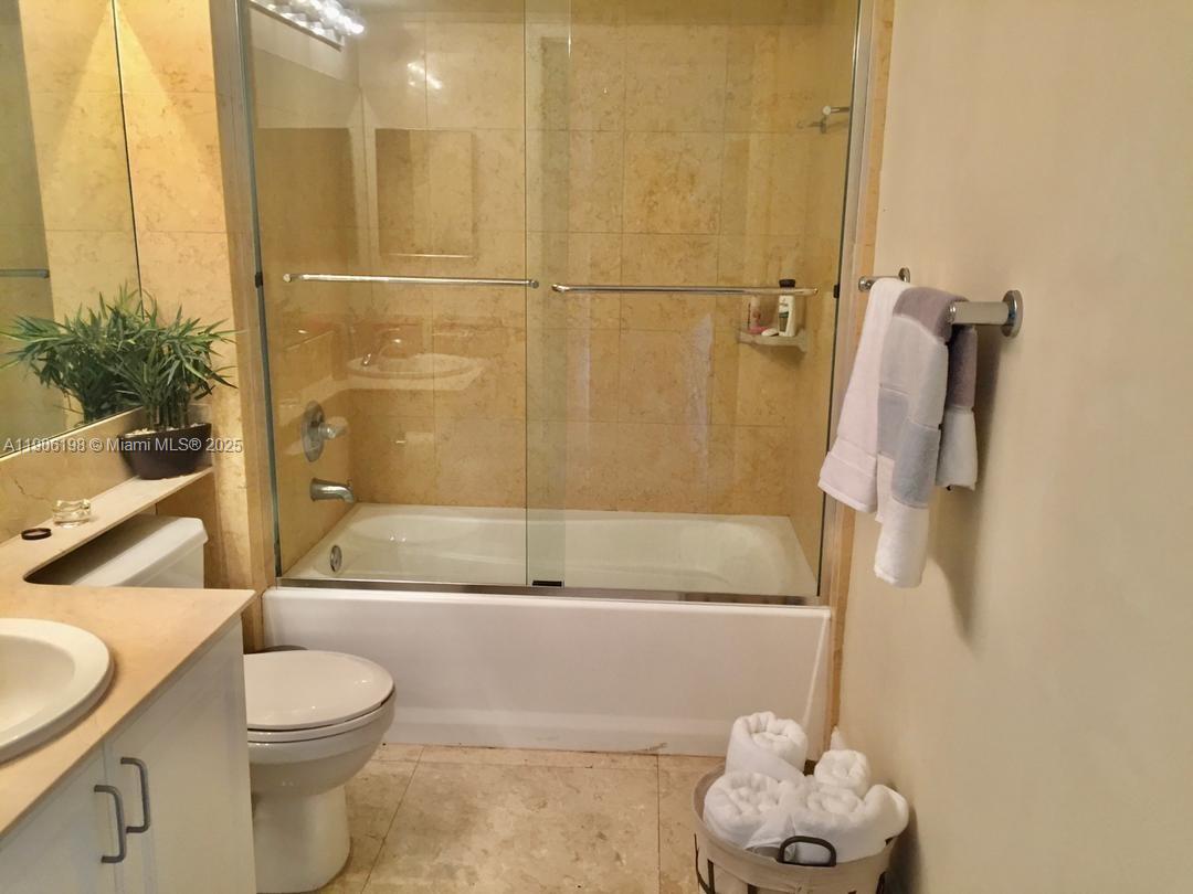 1155 Brickell Bay Drive, Unit 705 Miami, FL 33131 - Photo 13 of 20 a bathroom with a granite countertop bathtub sink vanity mirror and toilet