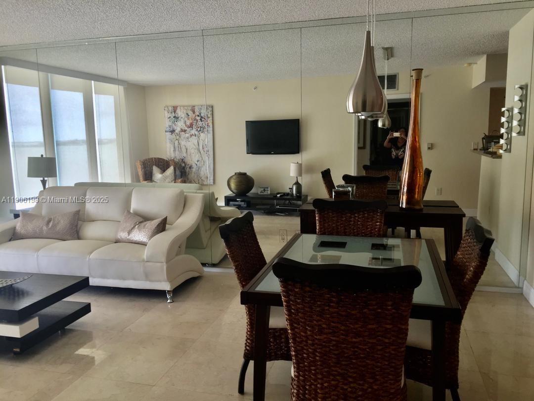1155 Brickell Bay Drive, Unit 705 Miami, FL 33131 - Photo 17 of 20 a living room with furniture and a flat screen tv