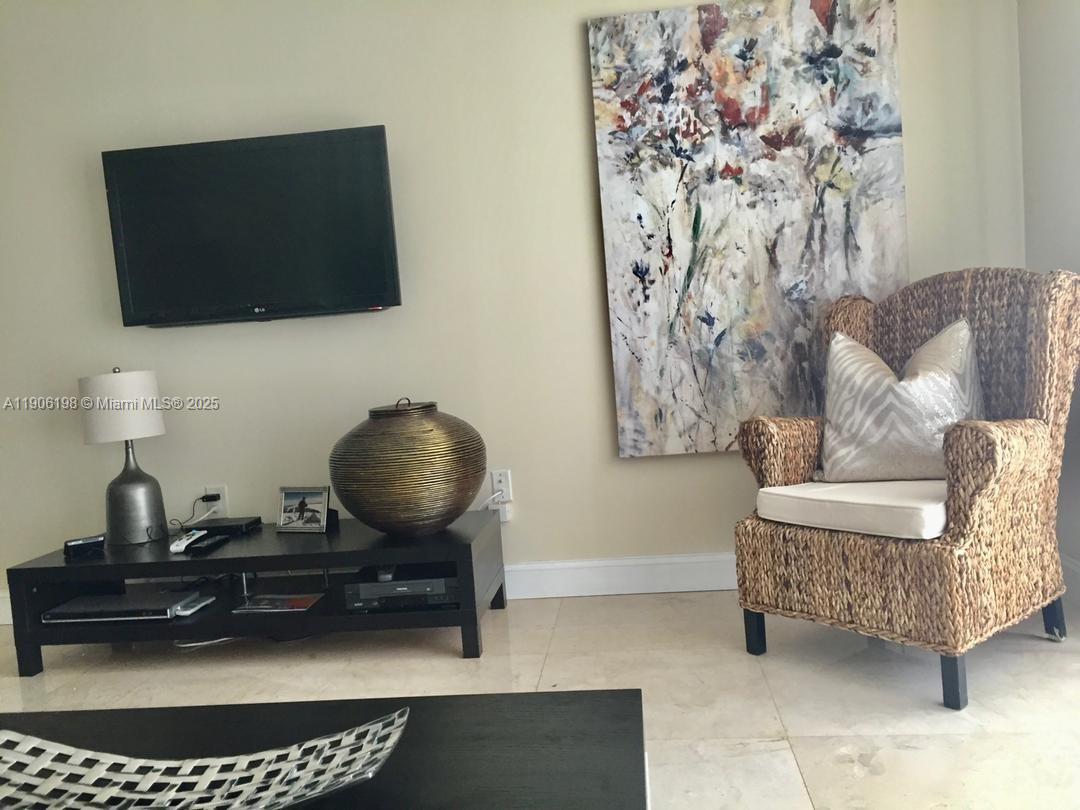 1155 Brickell Bay Drive, Unit 705 Miami, FL 33131 - Photo 4 of 20 a living room with furniture and a flat screen tv