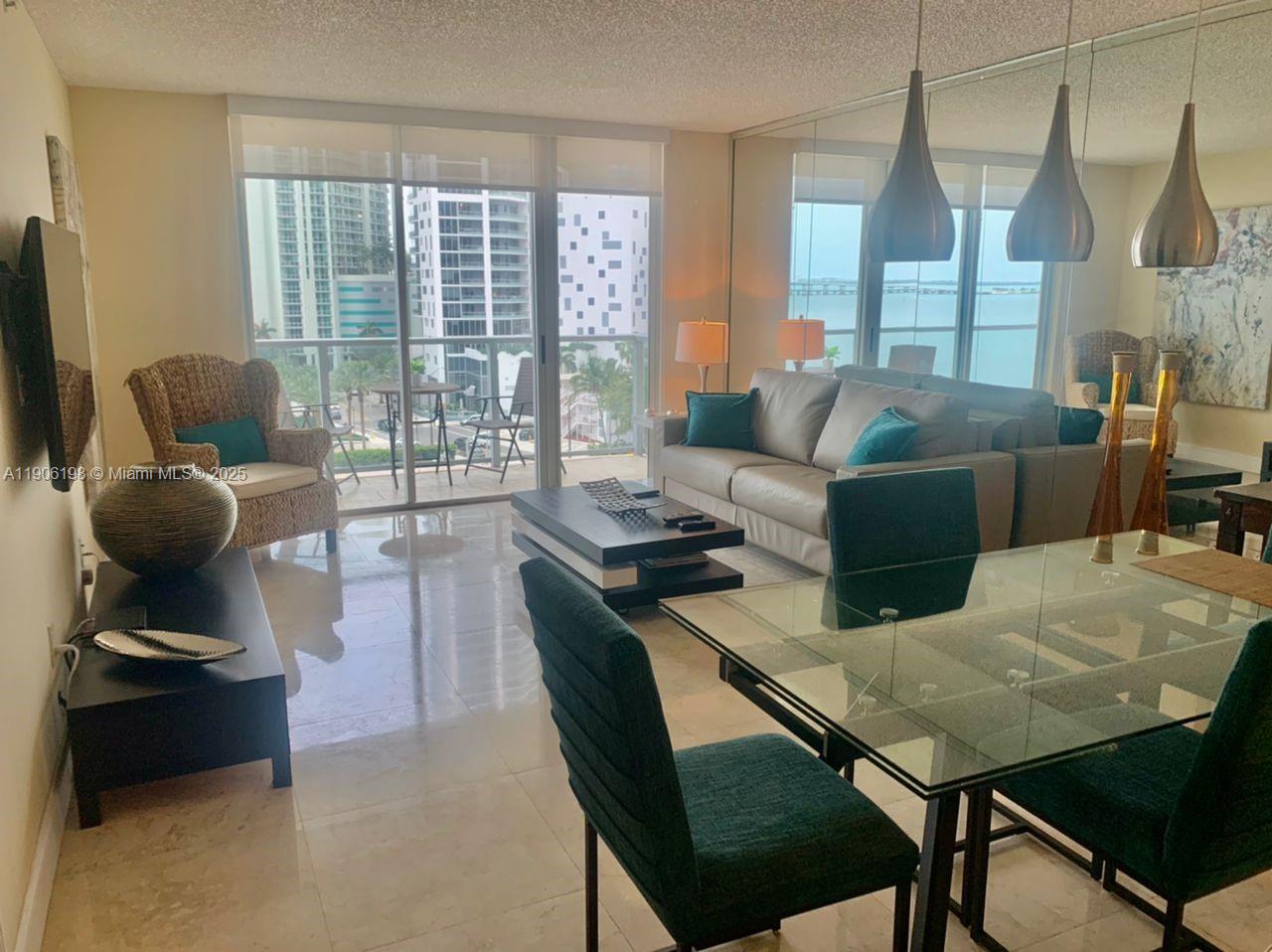 1155 Brickell Bay Drive, Unit 705 Miami, FL 33131 - Photo 6 of 20 a living room with furniture and a large window