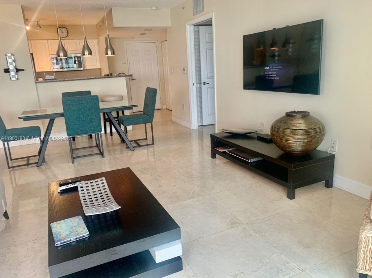 1155 Brickell Bay Drive, Unit 705 Miami, FL 33131 - Photo 8 of 20 a living room with furniture and a flat screen tv