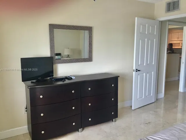 a living room with a dresser and a television