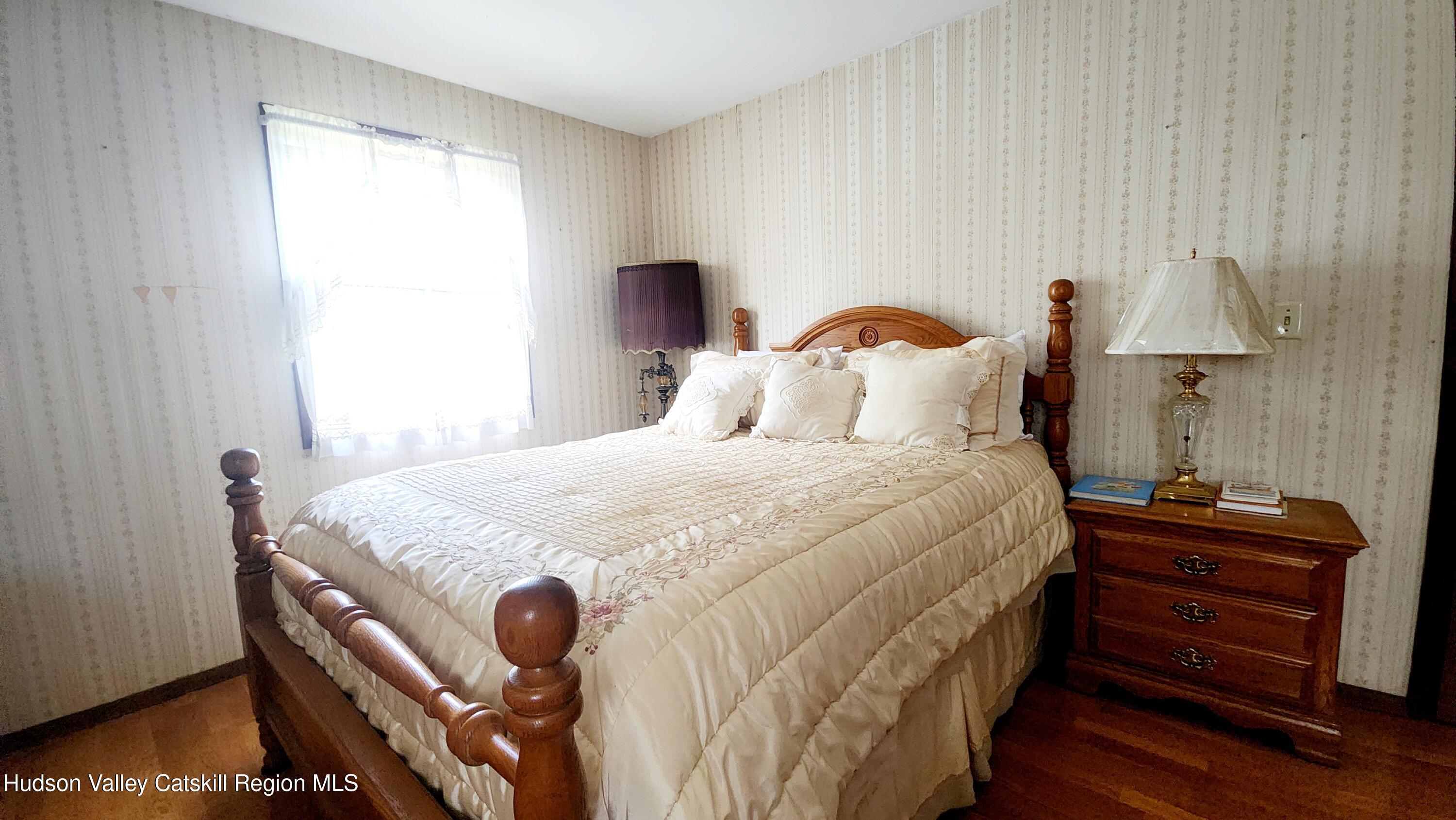 17 Clay Hill Road Durham, NY 12423 - Photo 8 of 15 a bedroom with a bed and a lamp on dresser