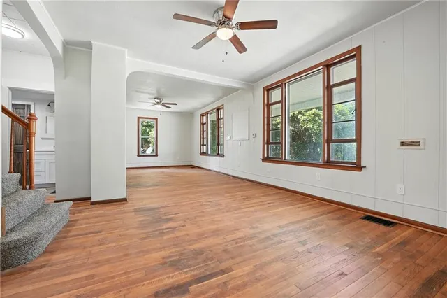a view of an empty room with a window and wooden floor