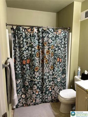 a bathroom with a toilet and a shower curtain