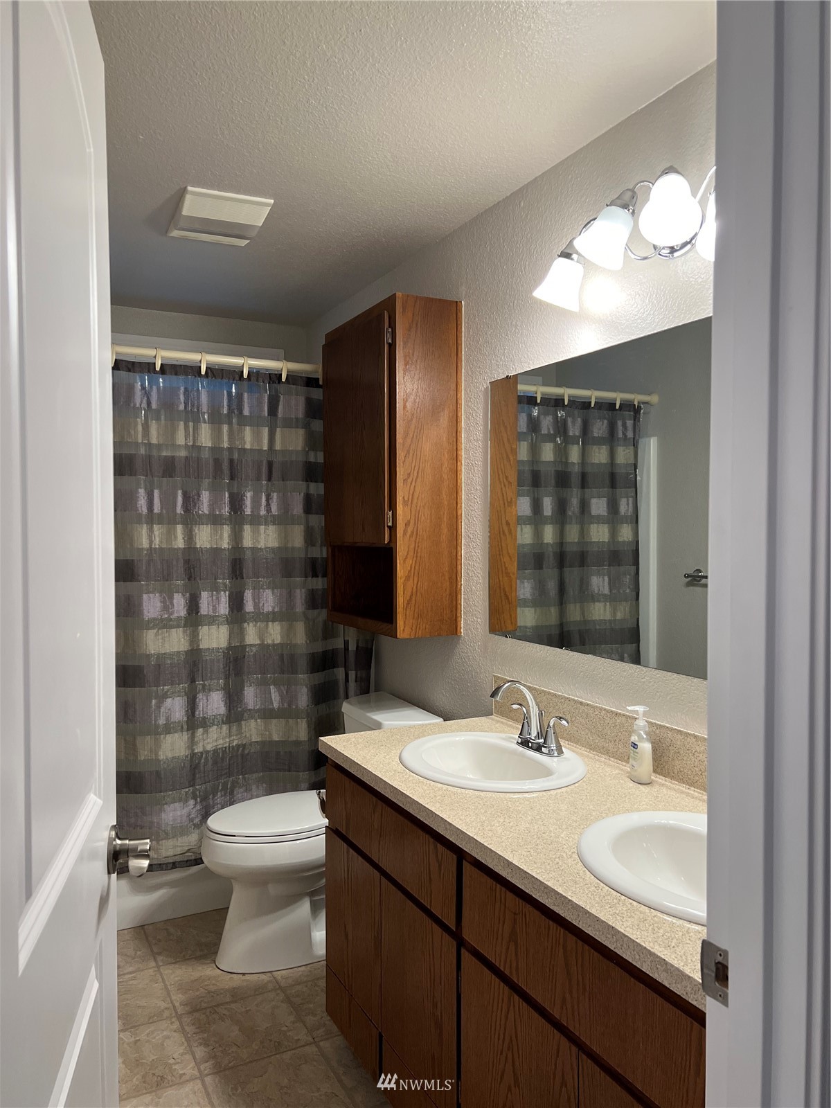 7407 Vandermark Road East Bonney Lake, WA 98391 - Photo 5 of 30 a bathroom with a double vanity sink toilet and shower