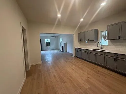 a large kitchen with stainless steel appliances granite countertop a sink and wooden floors