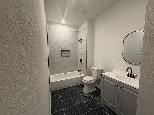 a bathroom with a toilet sink vanity tub and shower