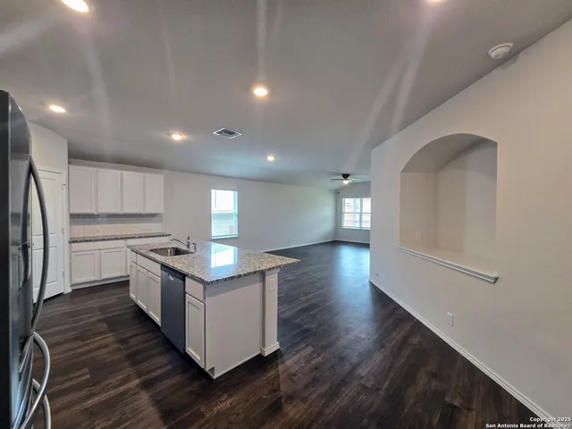 a kitchen with granite countertop a sink and a refrigerator