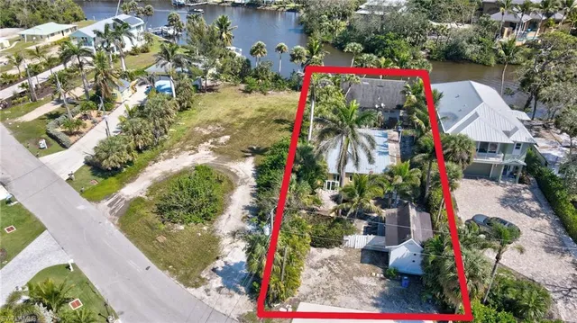 an aerial view of a house with a yard and lake view