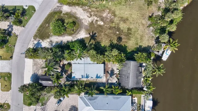 an aerial view of a houses with a yard and lake