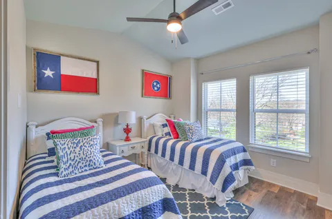 a bedroom with two beds and a chandelier