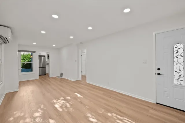 a view of a big room with wooden floor and windows