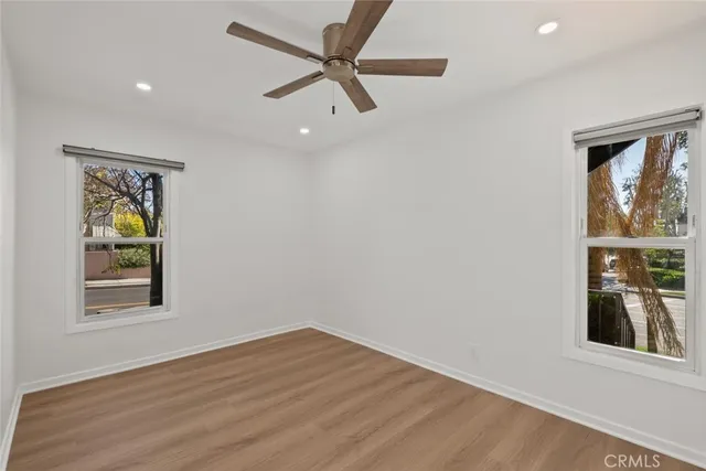 an empty room with a window and ceiling fan