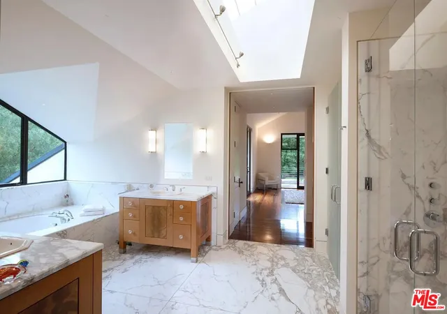 a bedroom with a bed and large windows