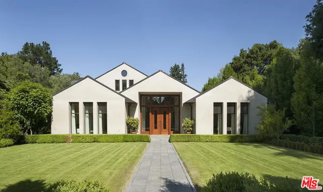 a front view of a house with yard and green space