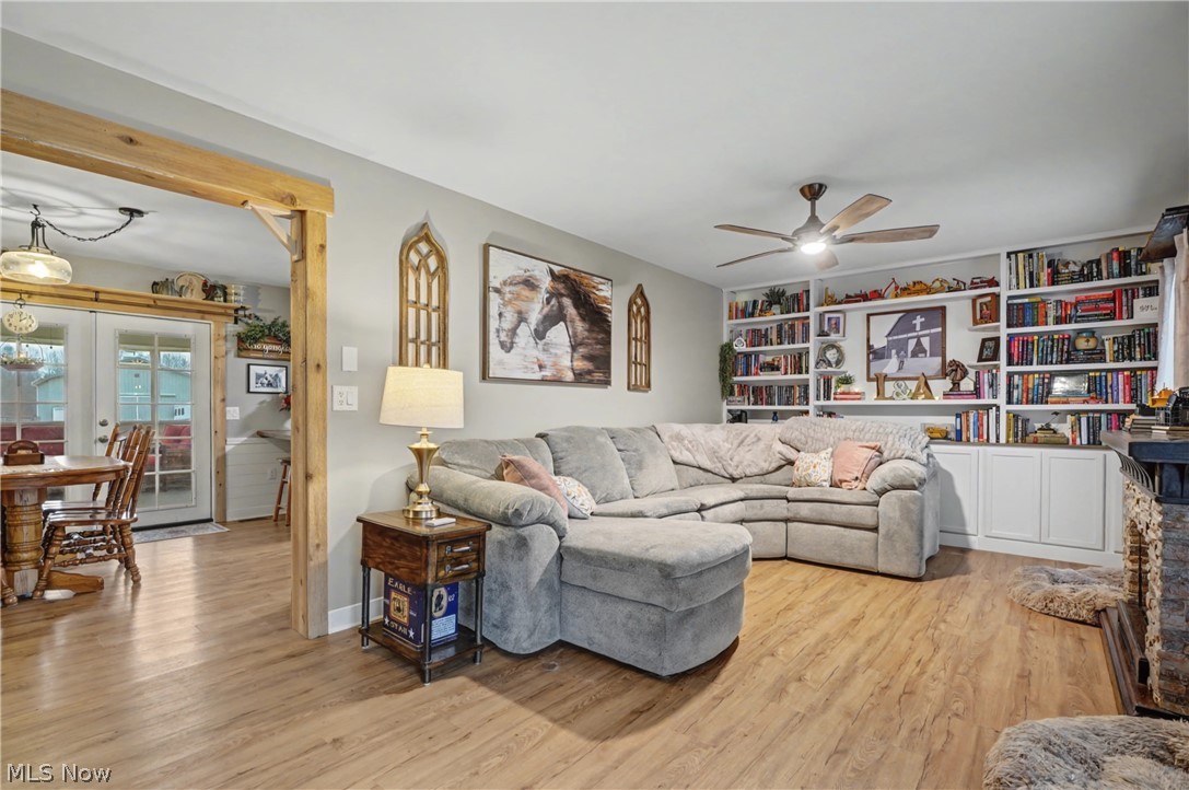 Living area with light wood-type flooring, a ceiling fan, and french doors
