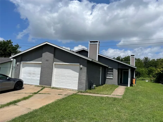a front view of house with yard and trees in the background