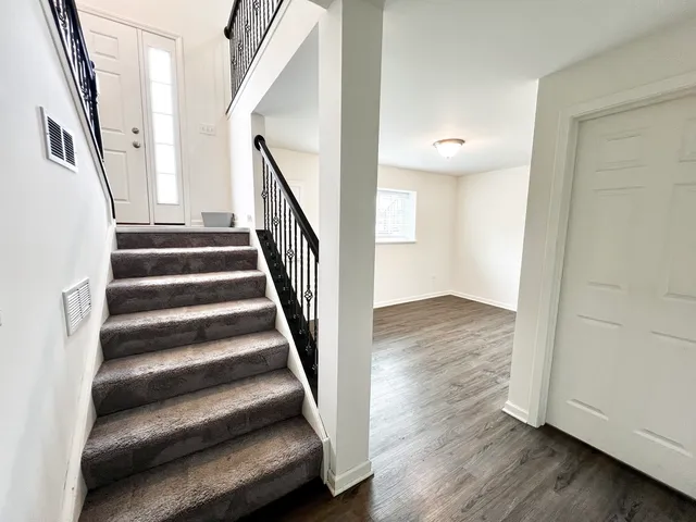 a view of entryway with wooden floor and stairs