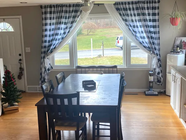 a dining room with furniture and a window