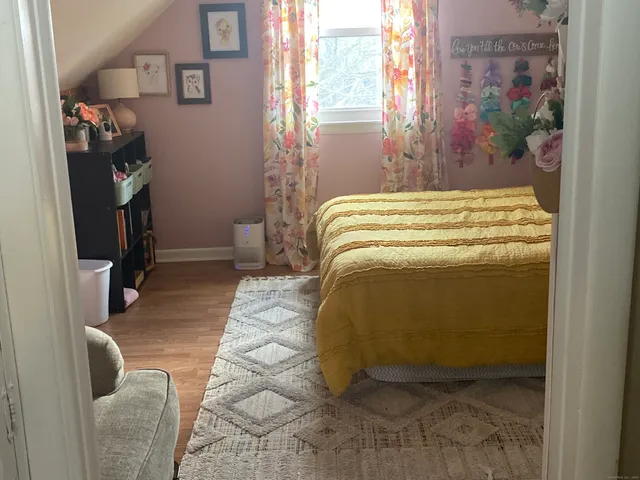 a bedroom with a bed and a painting on the wall