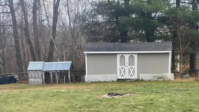 a view of a house with a yard and large tree