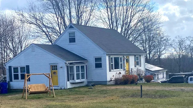 a view of a house with a yard and large tree