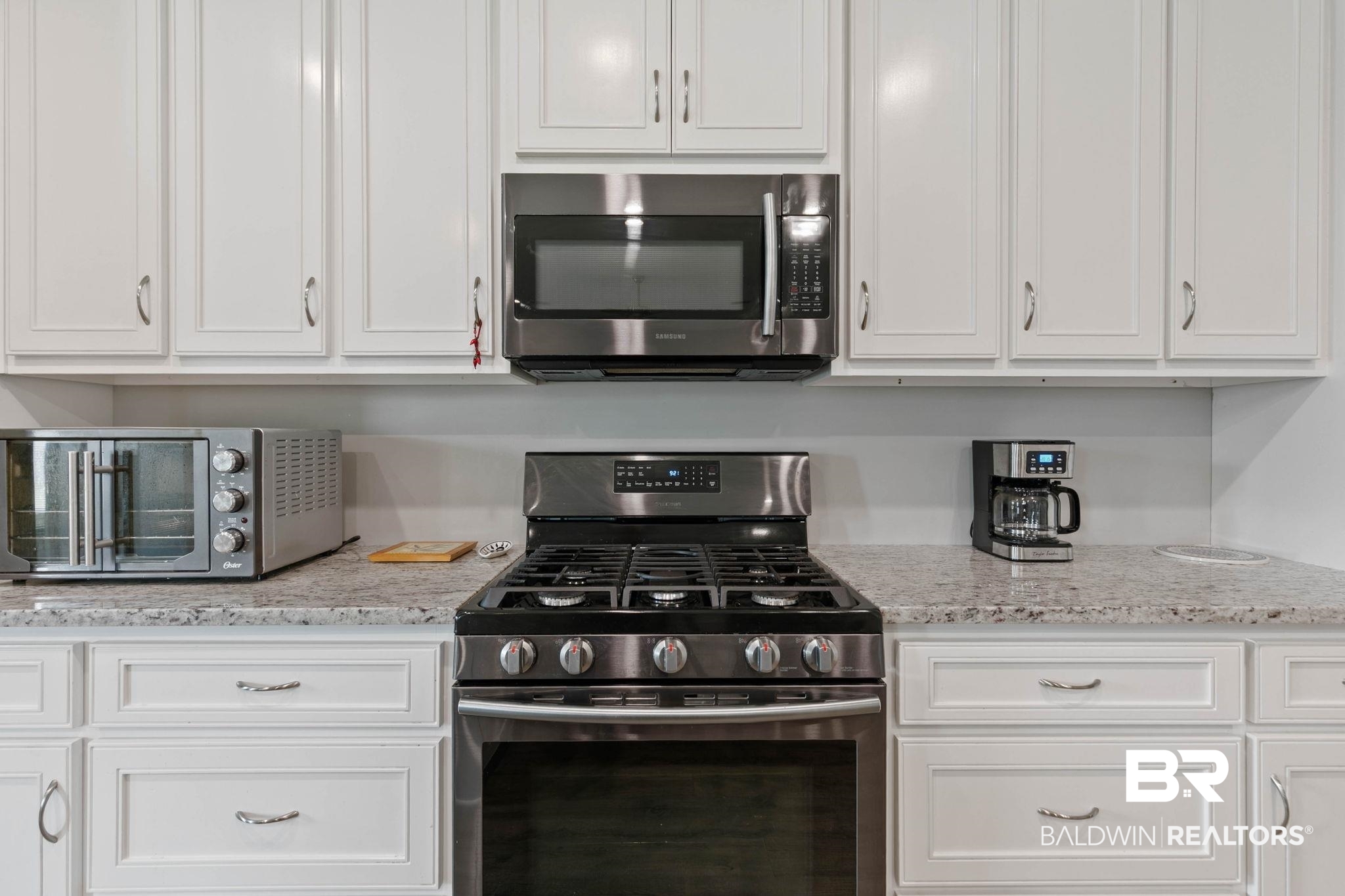 9388 Pembrook Loop Fairhope, AL 36532 - Photo 25 of 53 Kitchen featuring stainless steel appliances, white cabinets, and light stone countertops