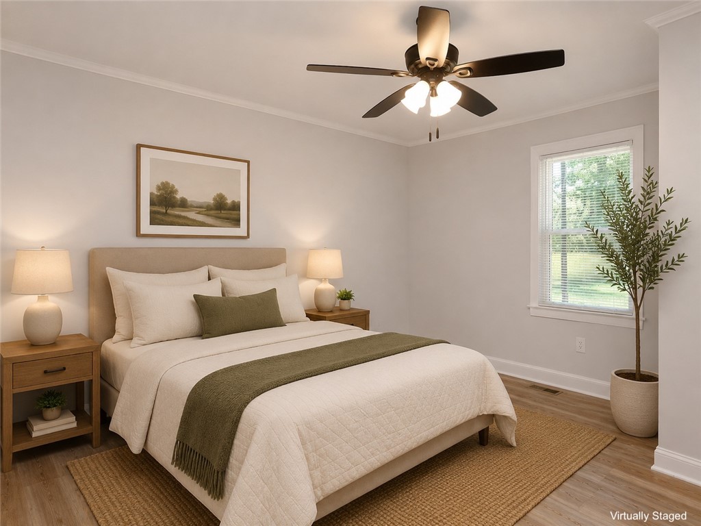 3517 Shawnee Avenue Anderson, SC 29626 - Photo 9 of 25 Relax in this tranquil bedroom, featuring light wood-look flooring and a functional ceiling fan with integrated lighting.