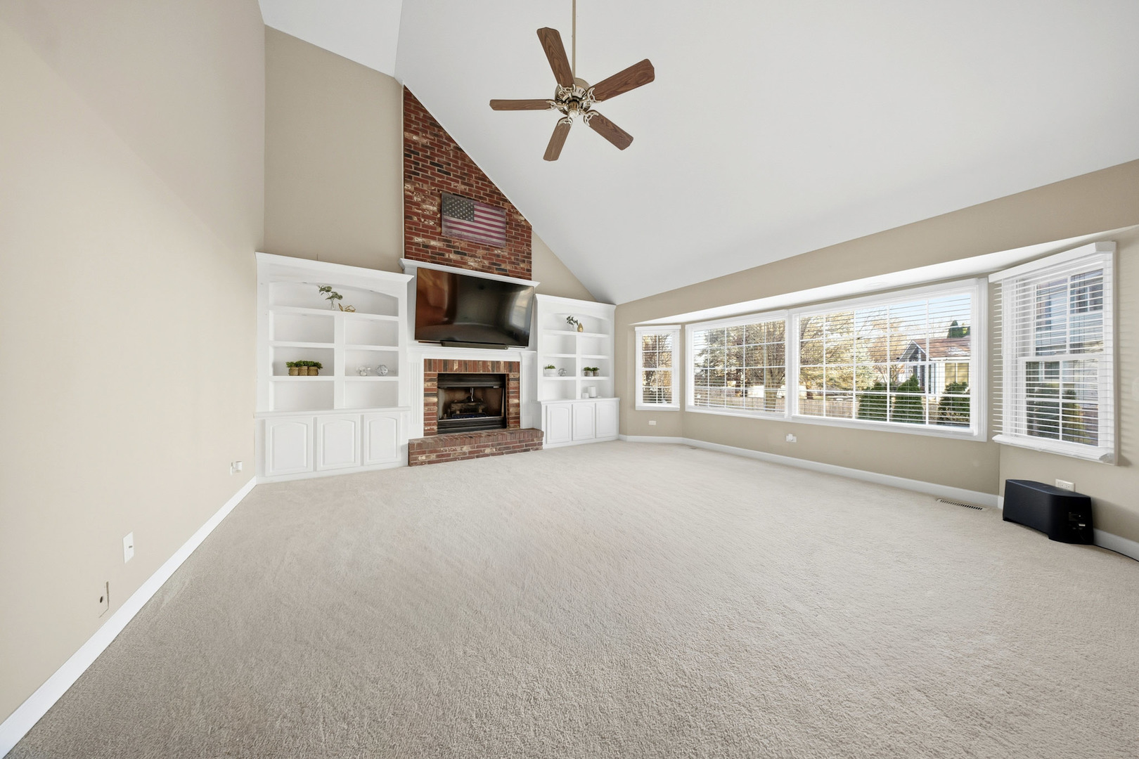 548 Arbor Lane Oswego, IL 60543 - Photo 14 of 46 a view of an empty room with a fireplace and a ceiling fan