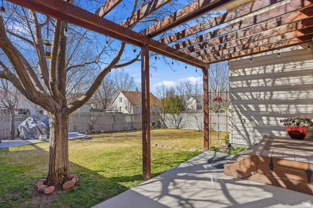 7737 Ranches Parkway Eagle Mountain, UT 84005 - Photo 22 of 28 Rear patio featuring a wood pergola with string lighting, concrete slab, wood-finish composite deck, and vinyl siding exterior