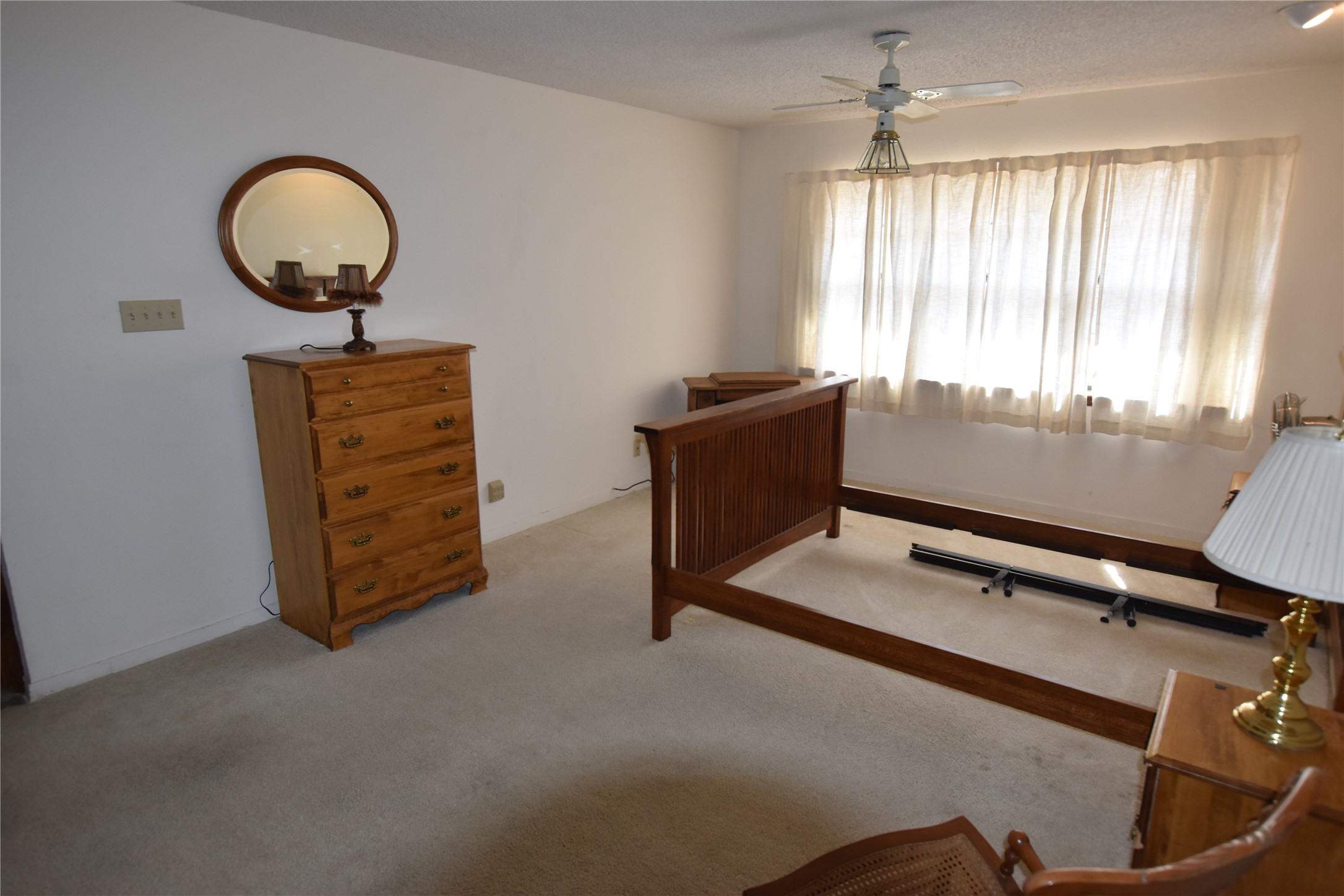 687 Fm 812 Road Red Rock, TX 78662 - Photo 32 of 40 Bedroom featuring light carpet, ceiling fan, and a textured ceiling