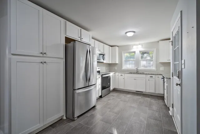 a kitchen with white cabinets and white stainless steel appliances