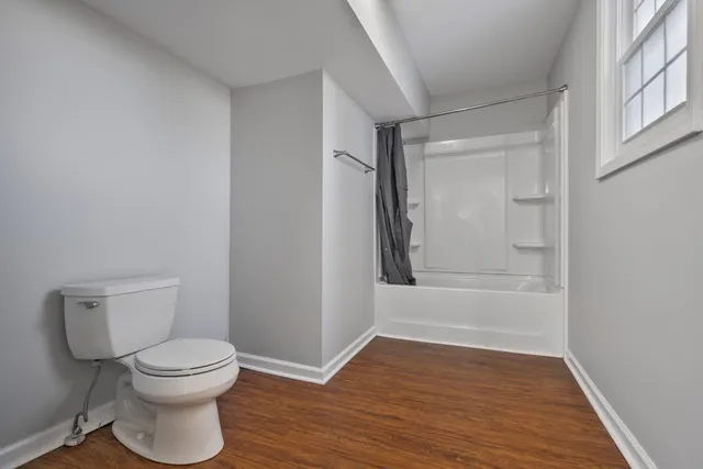 a bathroom with a toilet and a shower