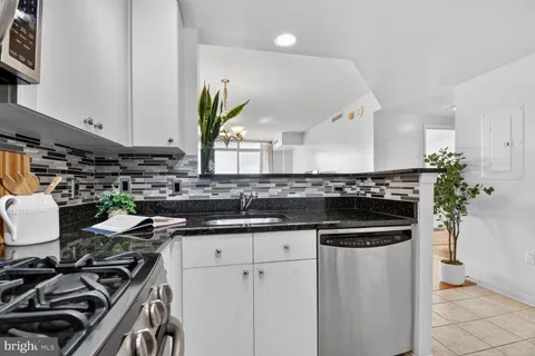 a kitchen with stainless steel appliances a sink stove and cabinets