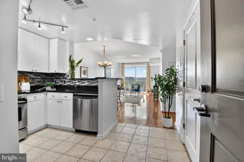 a kitchen with white cabinets and counter space