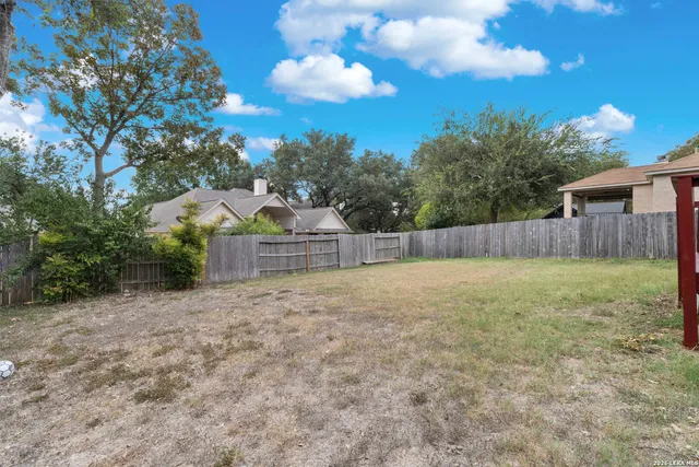a view of a yard with wooden fence