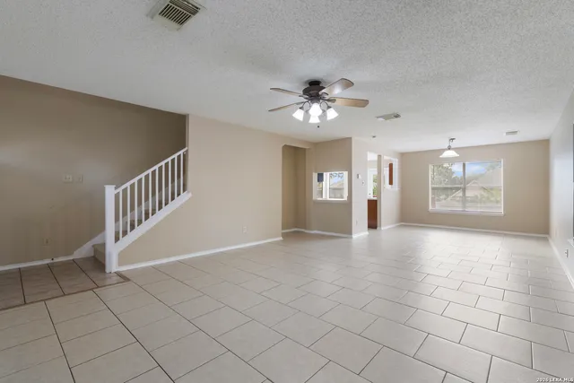 an empty room with windows and fan